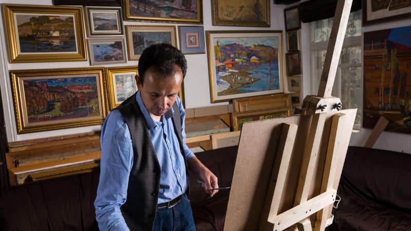 Un artiste peintre dans son atelier en train de peindre